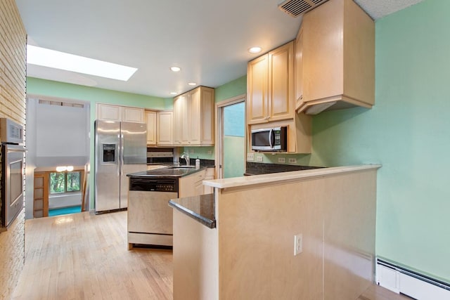 364 Owasso Blvd N, Shoreview, MN 55126 - kitchen featuring appliances with stainless steel finishes, a baseboard radiator, a sink, dark countertops, and a skylight