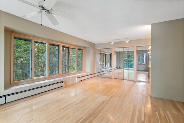 364 Owasso Blvd N, Shoreview, MN 55126 - unfurnished room featuring a ceiling fan, a baseboard radiator, wood finished floors, and rail lighting