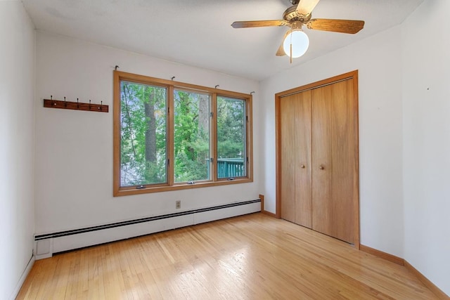 364 Owasso Blvd N, Shoreview, MN 55126 - unfurnished bedroom with baseboard heating, light wood-type flooring, a closet, baseboards, and a ceiling fan