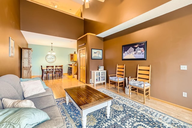 12729 Eagle St NW, Coon Rapids, MN 55448 - living area with wood finished floors, a chandelier, baseboards, a ceiling fan, and a towering ceiling