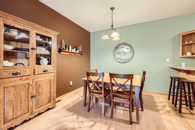 12729 Eagle St NW, Coon Rapids, MN 55448 - dining room with light wood-style flooring, a chandelier, baseboards, and vaulted ceiling