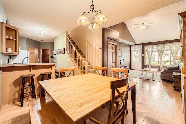 12729 Eagle St NW, Coon Rapids, MN 55448 - dining area featuring a ceiling fan, light wood-style floors, stairs, high vaulted ceiling, and a textured ceiling