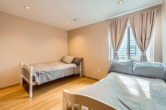 12729 Eagle St NW, Coon Rapids, MN 55448 - bedroom with light wood-style flooring, baseboards, a textured ceiling, and recessed lighting