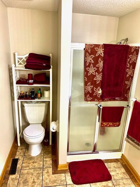 701 Parkview Ln N, Champlin, MN 55316 - full bath featuring a textured ceiling, toilet, and a stall shower
