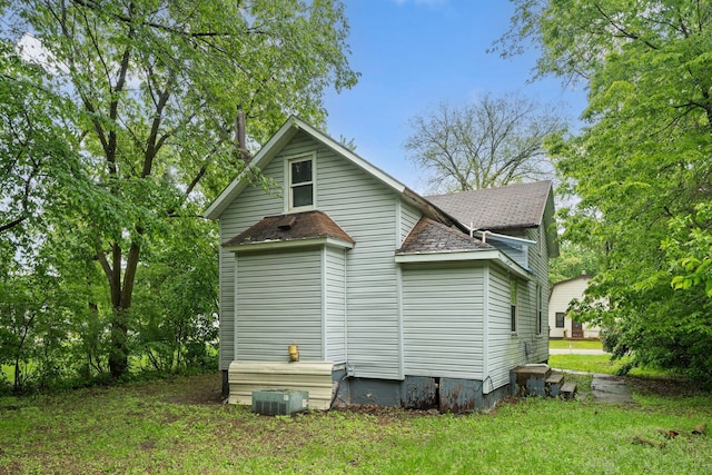 318 Austin Ave, Litchfield, MN 55355 - view of home's exterior featuring a shingled roof and a lawn