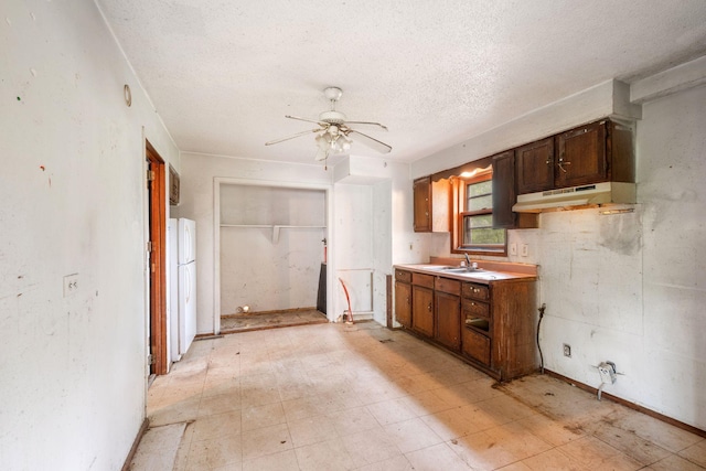 318 Austin Ave, Litchfield, MN 55355 - kitchen featuring under cabinet range hood, a sink, a textured ceiling, freestanding refrigerator, and a ceiling fan
