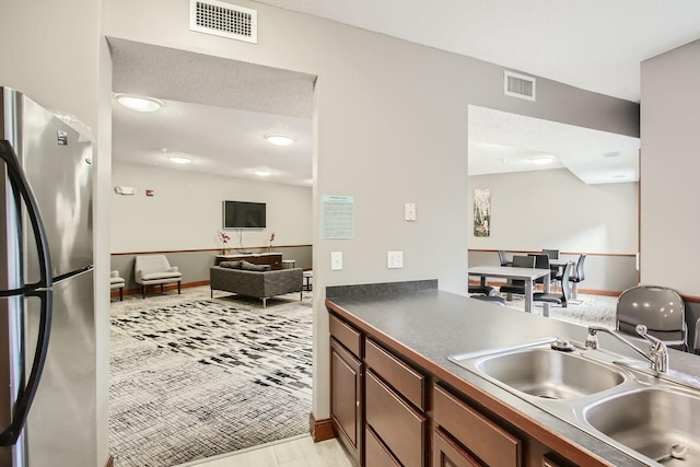 4824 53rd St Unit 410, Minneapolis, MN 55417 - kitchen with freestanding refrigerator, a sink, dark countertops, open floor plan, and baseboards