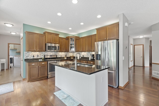4231 Maple Hurst Dr N, Rockford, MN 55373 - kitchen with appliances with stainless steel finishes, independent washer and dryer, brown cabinets, a textured ceiling, and recessed lighting