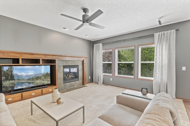 4231 Maple Hurst Dr N, Rockford, MN 55373 - carpeted living area featuring ceiling fan, a textured ceiling, and a tiled fireplace