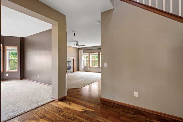 4231 Maple Hurst Dr N, Rockford, MN 55373 - unfurnished room featuring ceiling fan, wood finished floors, a tile fireplace, and a textured ceiling