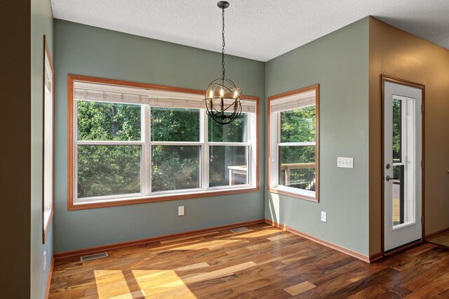 4231 Maple Hurst Dr N, Rockford, MN 55373 - empty room featuring wood finished floors, a chandelier, and a textured ceiling