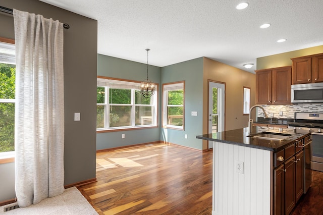 4231 Maple Hurst Dr N, Rockford, MN 55373 - kitchen featuring stainless steel appliances, tasteful backsplash, dark wood-style floors, a chandelier, and a textured ceiling