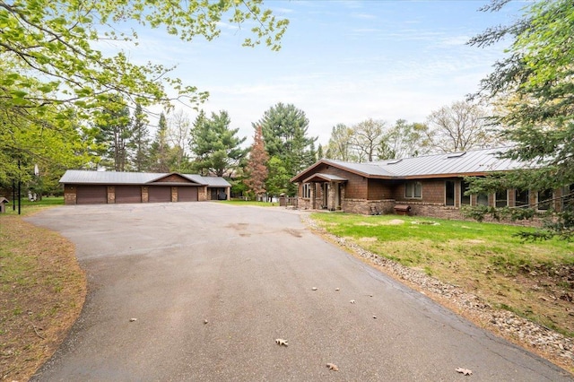 11567 S Lake Blvd, Lake Nebagamon, WI 54849 - view of front of property with stone siding, a garage, metal roof, and a front yard