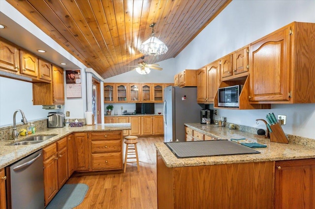 11567 S Lake Blvd, Lake Nebagamon, WI 54849 - kitchen featuring a sink, appliances with stainless steel finishes, a peninsula, lofted ceiling, and light stone countertops
