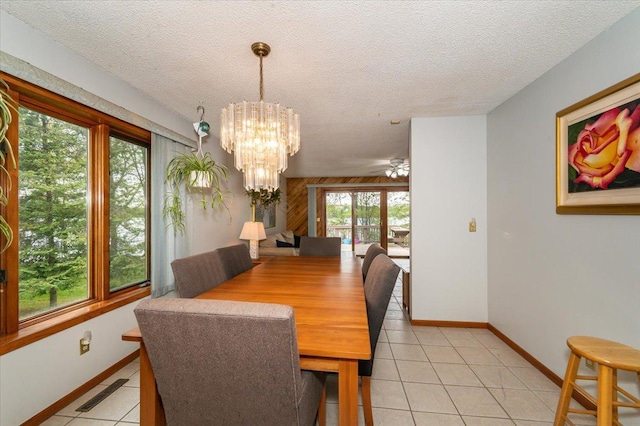 11567 S Lake Blvd, Lake Nebagamon, WI 54849 - dining area with light tile patterned floors, a chandelier, a textured ceiling, and baseboards