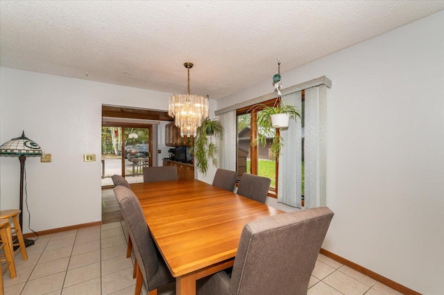 11567 S Lake Blvd, Lake Nebagamon, WI 54849 - dining area with light tile patterned floors, a chandelier, a textured ceiling, and baseboards