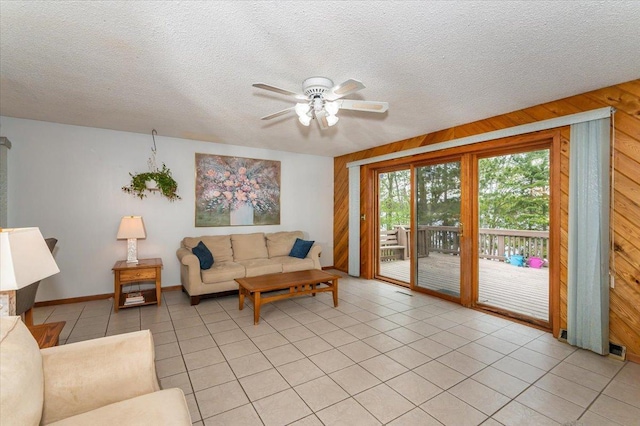 11567 S Lake Blvd, Lake Nebagamon, WI 54849 - living room with light tile patterned floors, a textured ceiling, wood walls, and a ceiling fan