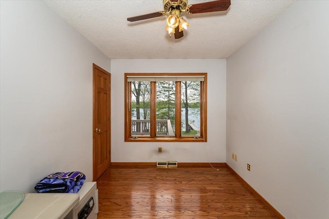 11567 S Lake Blvd, Lake Nebagamon, WI 54849 - empty room with wood finished floors, a textured ceiling, ceiling fan, and baseboards