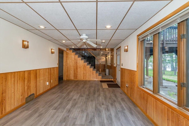 11567 S Lake Blvd, Lake Nebagamon, WI 54849 - basement featuring wood walls, a wainscoted wall, wood finished floors, ceiling fan, and stairway