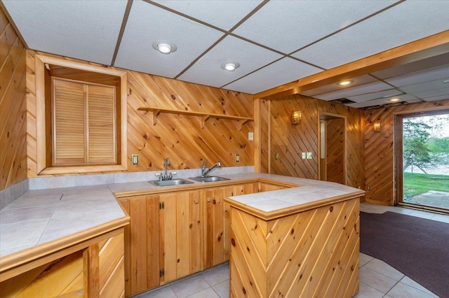 11567 S Lake Blvd, Lake Nebagamon, WI 54849 - kitchen with tile countertops, light tile patterned floors, wood walls, a peninsula, and recessed lighting