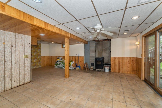 11567 S Lake Blvd, Lake Nebagamon, WI 54849 - basement with a wainscoted wall, wood walls, a wood stove, a ceiling fan, and recessed lighting