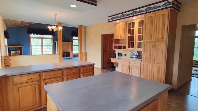 8848 Leander Rd, Angora Twp, MN 55723 - kitchen with a chandelier, glass insert cabinets, hanging light fixtures, a fireplace, and light brown cabinets
