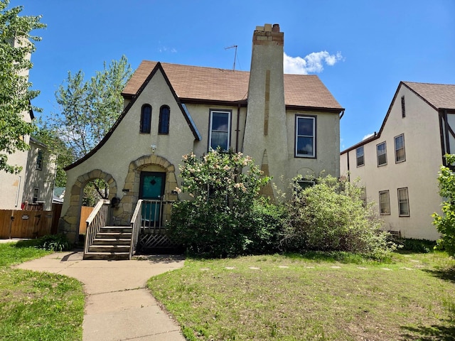 4429 Portland Ave, Minneapolis, MN 55407 - view of front facade featuring stucco siding, a chimney, a front lawn, and a shingled roof