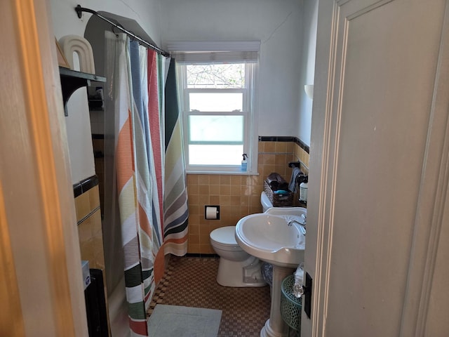 4429 Portland Ave, Minneapolis, MN 55407 - bathroom with toilet, a sink, a shower with shower curtain, tile walls, and wainscoting