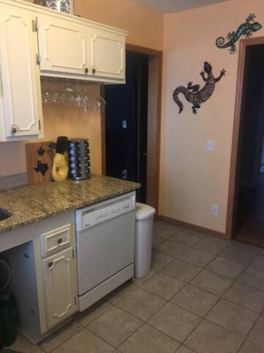 4429 Portland Ave, Minneapolis, MN 55407 - kitchen with white dishwasher, white cabinets, light tile patterned floors, and light stone counters