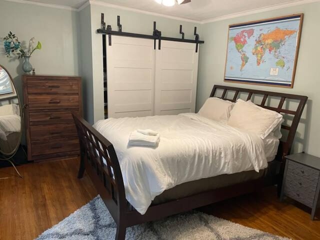4429 Portland Ave, Minneapolis, MN 55407 - bedroom with wood finished floors, ornamental molding, and a barn door