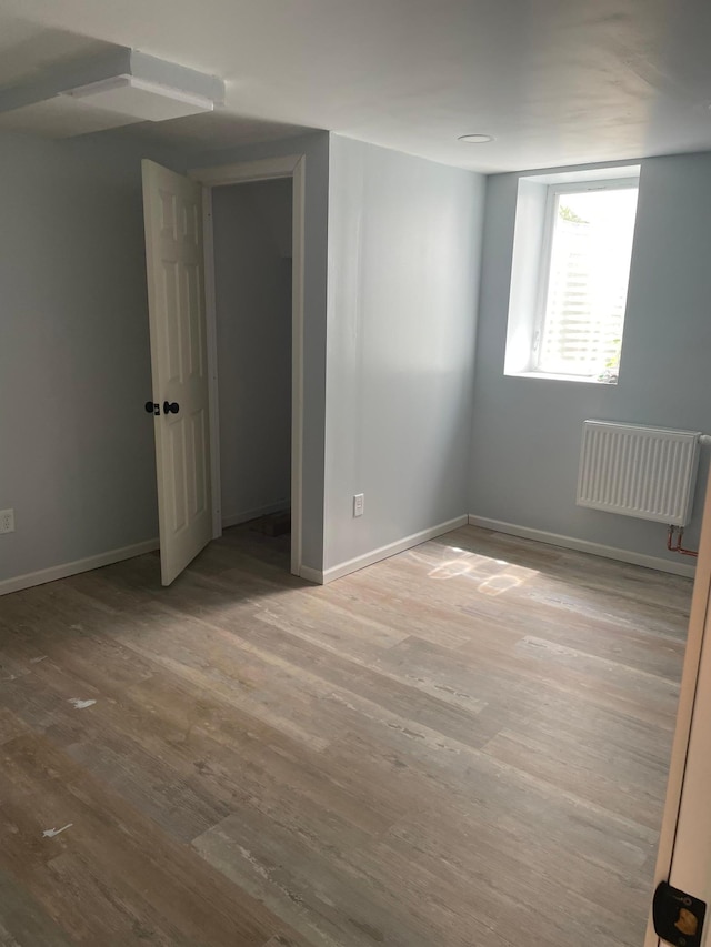 4429 Portland Ave, Minneapolis, MN 55407 - unfurnished bedroom with wood finished floors, baseboards, and radiator heating unit