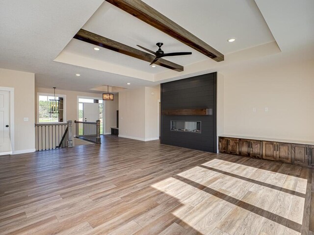 20666 Tamarack St NW, Oak Grove, MN 55011 - unfurnished living room featuring light wood-type flooring, baseboards, a fireplace, a ceiling fan, and beam ceiling
