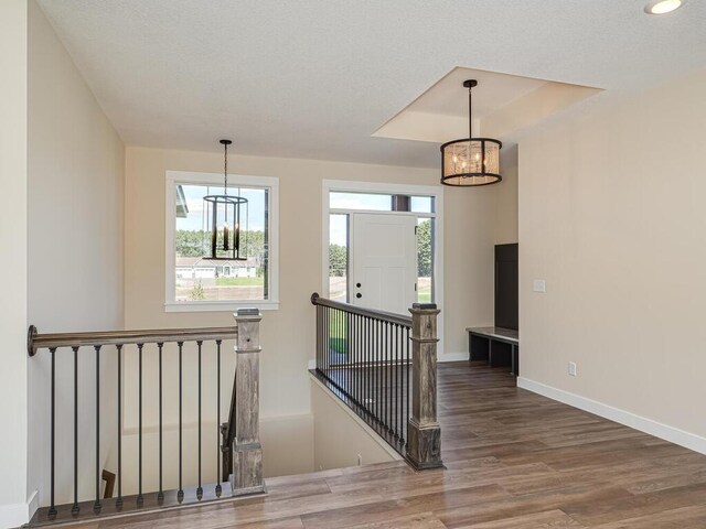 20666 Tamarack St NW, Oak Grove, MN 55011 - stairs featuring a chandelier, wood finished floors, baseboards, a tray ceiling, and recessed lighting