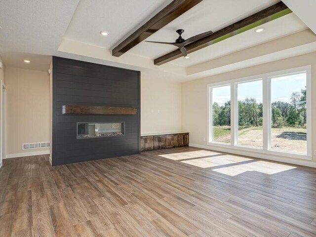 20666 Tamarack St NW, Oak Grove, MN 55011 - unfurnished living room featuring wood finished floors, ceiling fan, a fireplace, beamed ceiling, and baseboards