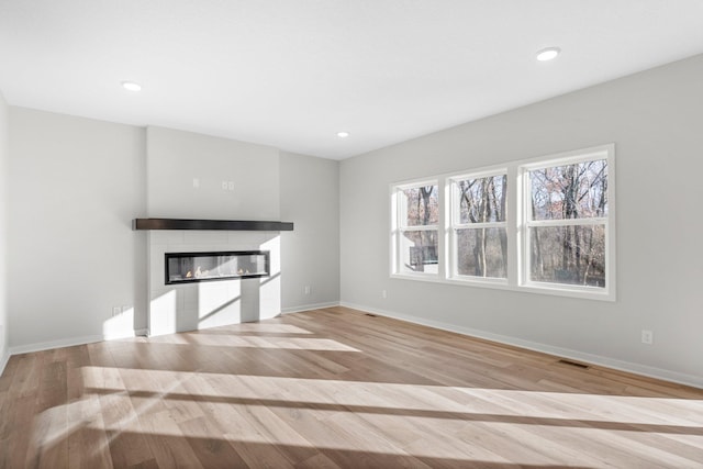 1708 Misty Cir, Buffalo, MN 55313 - unfurnished living room featuring a tile fireplace, light wood-type flooring, baseboards, and recessed lighting