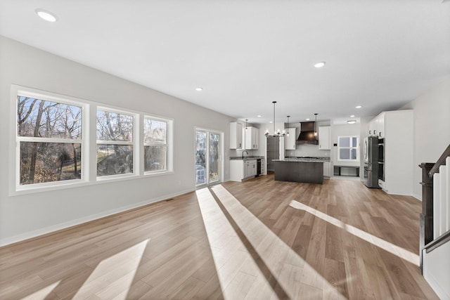1708 Misty Cir, Buffalo, MN 55313 - unfurnished living room featuring light wood-style flooring, a sink, recessed lighting, baseboards, and a chandelier