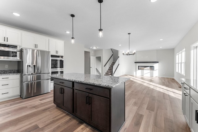 1708 Misty Cir, Buffalo, MN 55313 - kitchen with stainless steel appliances, light wood-style floors, recessed lighting, light stone counters, and decorative light fixtures
