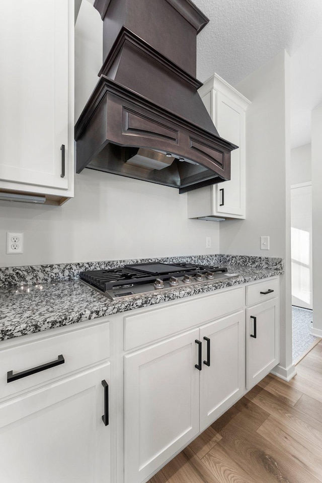 1708 Misty Cir, Buffalo, MN 55313 - kitchen with custom exhaust hood, stainless steel gas stovetop, light wood-style floors, white cabinets, and stone counters
