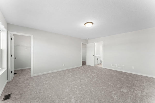 1708 Misty Cir, Buffalo, MN 55313 - unfurnished bedroom with a walk in closet, carpet flooring, baseboards, ensuite bathroom, and a closet