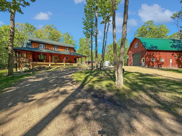 7215 Little Dip Ln NE, Bemidji, MN 56601 - view of front of property with an outdoor structure, a detached garage, covered porch, and dirt driveway