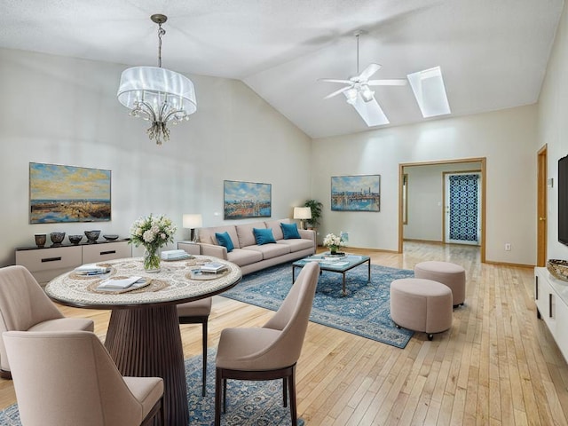 5420 Saxony Ct, White Bear Twp, MN 55110 - dining room with high vaulted ceiling, a skylight, light wood-style flooring, a ceiling fan, and a chandelier