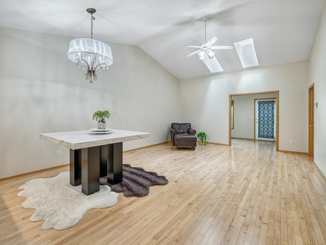 5420 Saxony Ct, White Bear Twp, MN 55110 - living area featuring a skylight, lofted ceiling, light wood-style floors, a chandelier, and ceiling fan