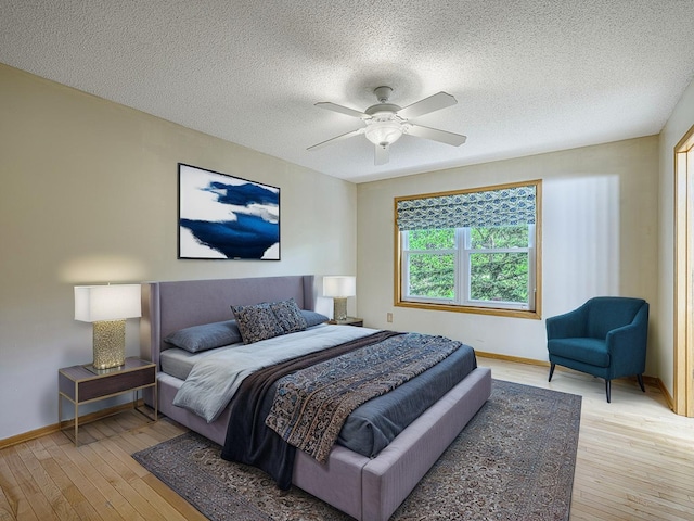 5420 Saxony Ct, White Bear Twp, MN 55110 - bedroom featuring light wood-style flooring, baseboards, a textured ceiling, and ceiling fan