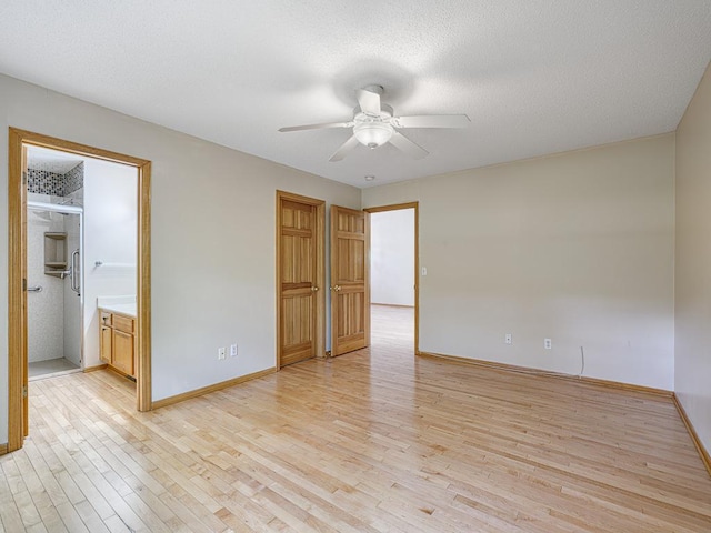 5420 Saxony Ct, White Bear Twp, MN 55110 - unfurnished bedroom featuring light wood-style flooring, baseboards, ceiling fan, a textured ceiling, and ensuite bathroom