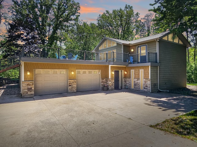 12216 175th St W, Lakeville, MN 55044 - view of front of home with stone siding, a balcony, a garage, and concrete driveway