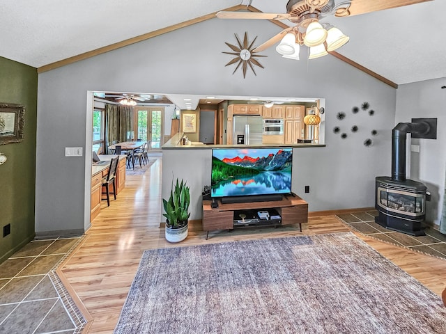 12216 175th St W, Lakeville, MN 55044 - living room with ceiling fan, vaulted ceiling, a wood stove, baseboards, and light wood-type flooring