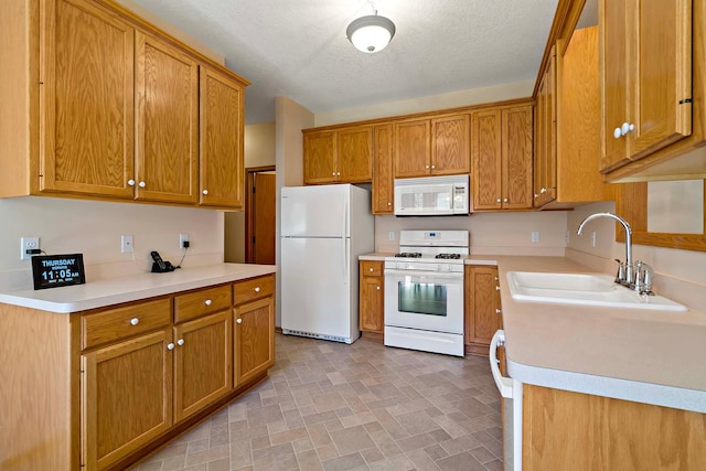 2990 David Cir, Little Canada, MN 55117 - kitchen featuring white appliances, a sink, light countertops, brown cabinetry, and a textured ceiling