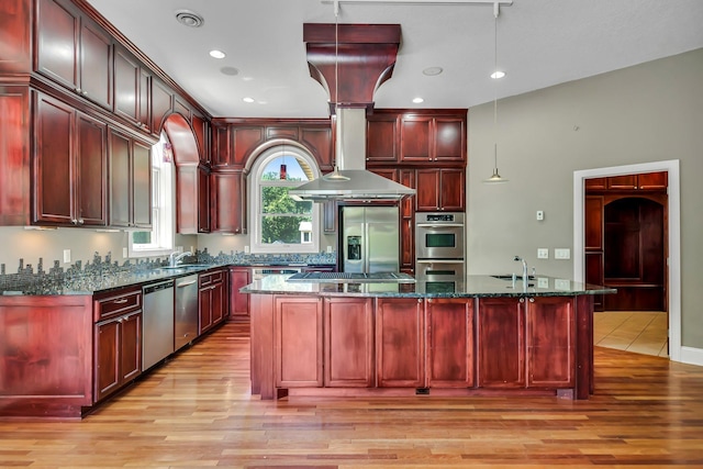 18141 87th Ave N, Maple Grove, MN 55311 - kitchen with reddish brown cabinets, appliances with stainless steel finishes, light wood-type flooring, a kitchen island, and dark stone countertops