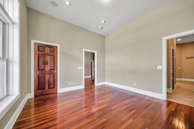 18141 87th Ave N, Maple Grove, MN 55311 - unfurnished bedroom featuring hardwood / wood-style floors, a towering ceiling, baseboards, and recessed lighting