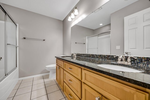 18141 87th Ave N, Maple Grove, MN 55311 - full bath with double vanity, tile patterned flooring, toilet, baseboards, and shower / bath combination with glass door
